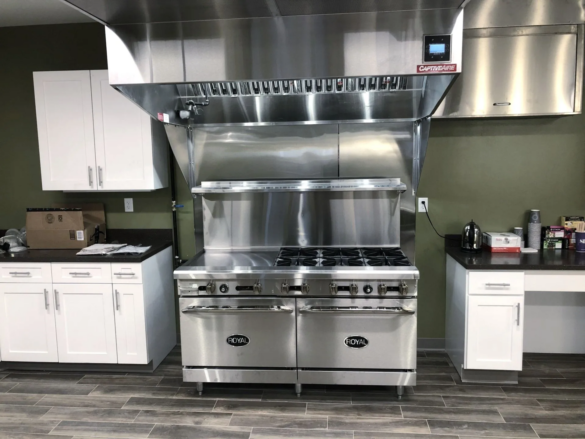 a stainless steel stove with a certified hood above it