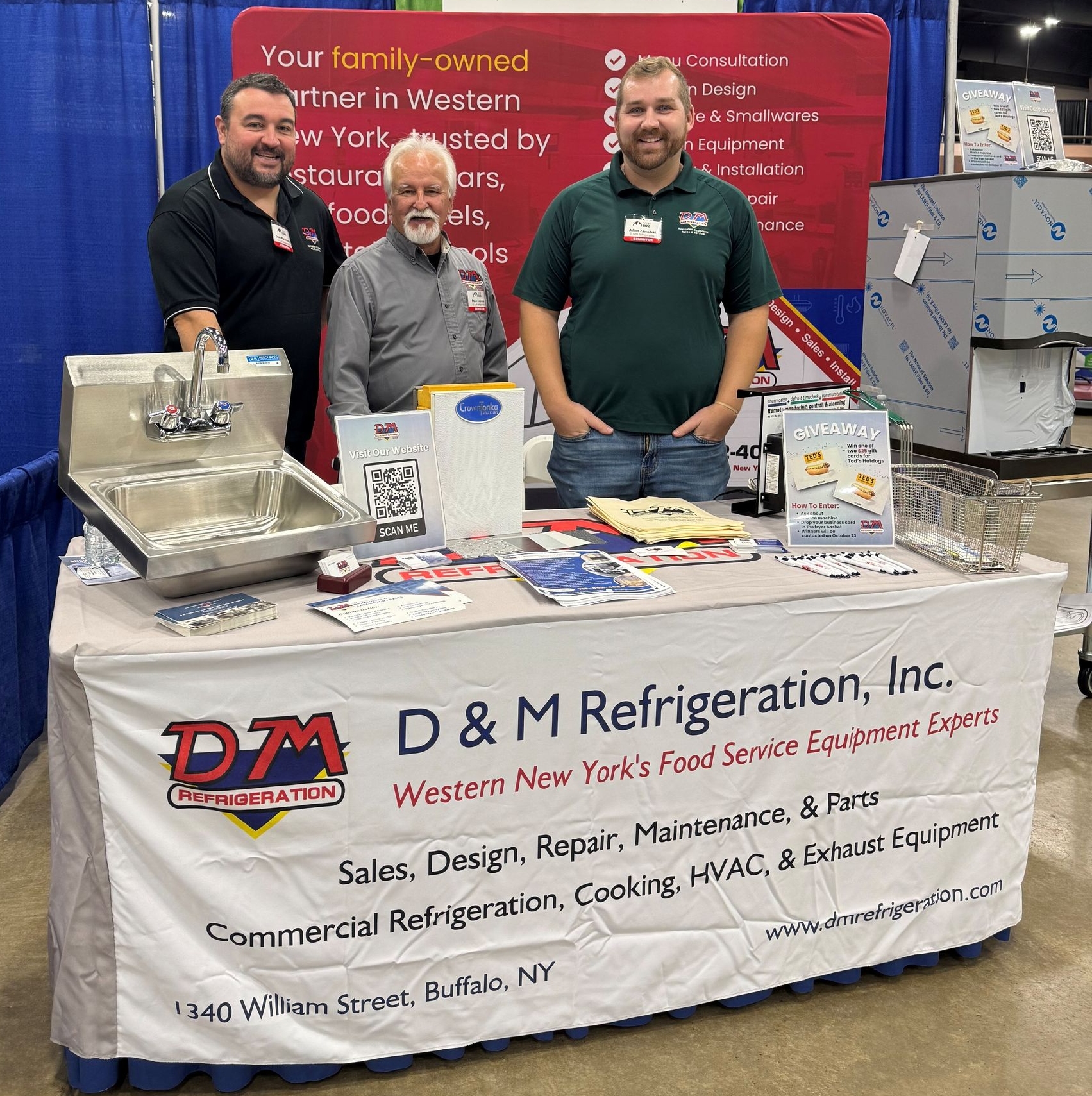 Employees posing for a picture in front of a Christmas tree