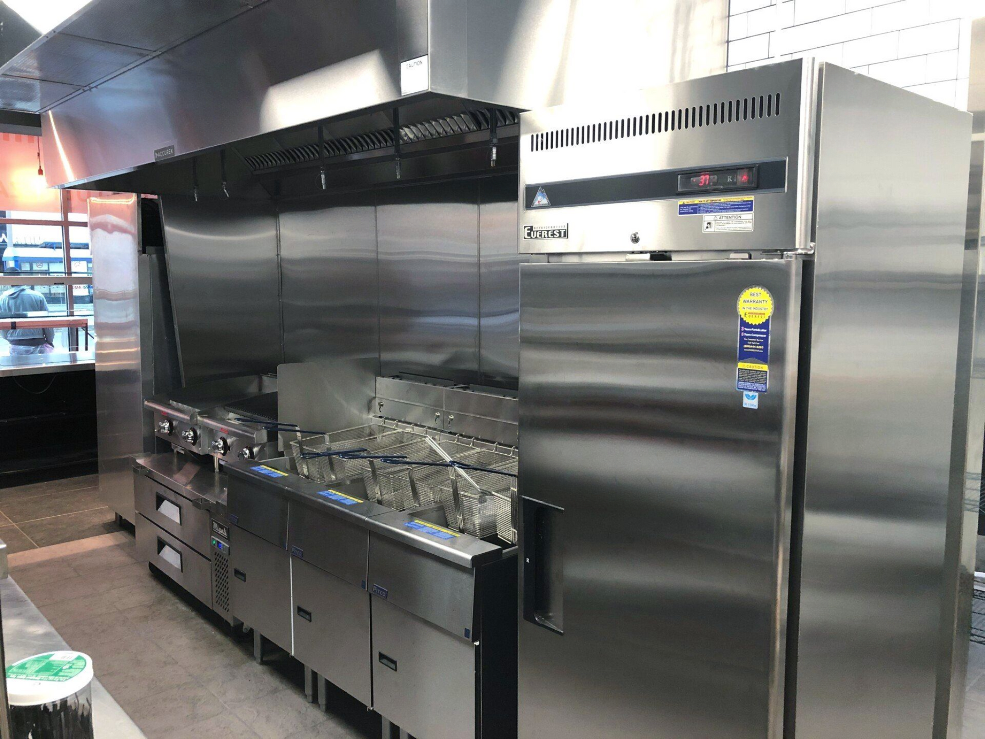 a stainless steel refrigerator, fryer, and stove 