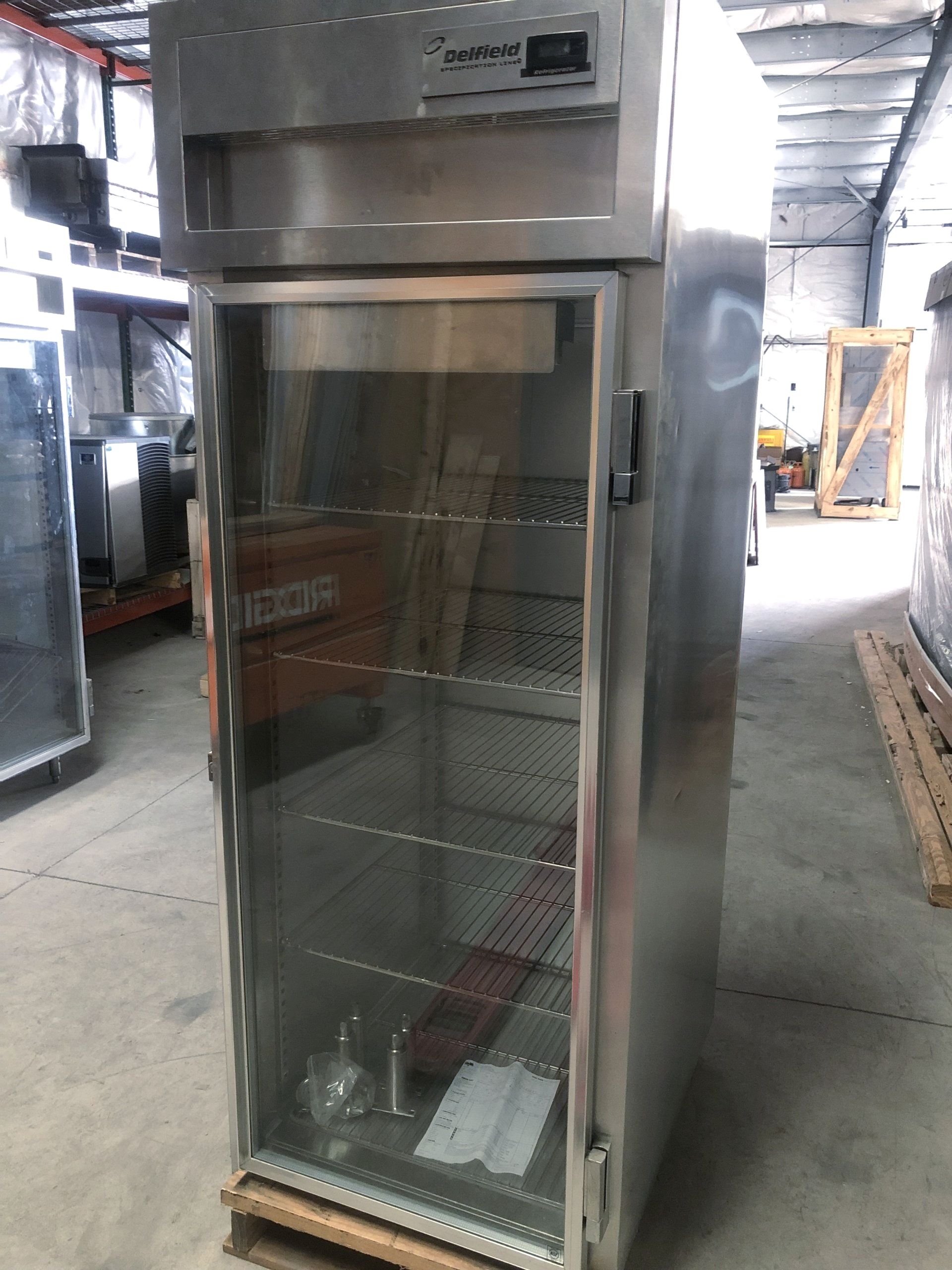 a stainless steel delfield refrigerator with a glass door