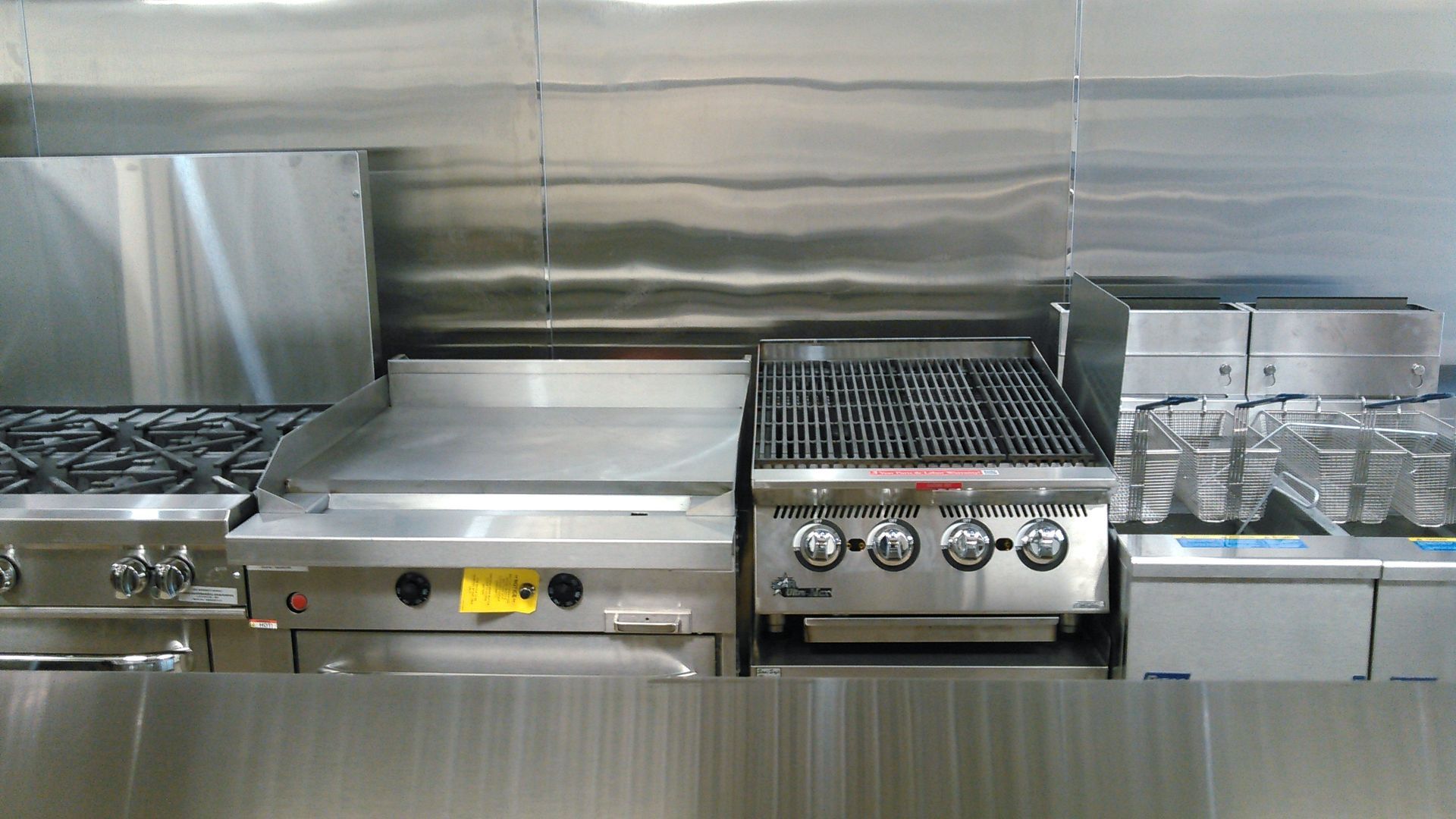 a kitchen with stainless steel appliances including a grill