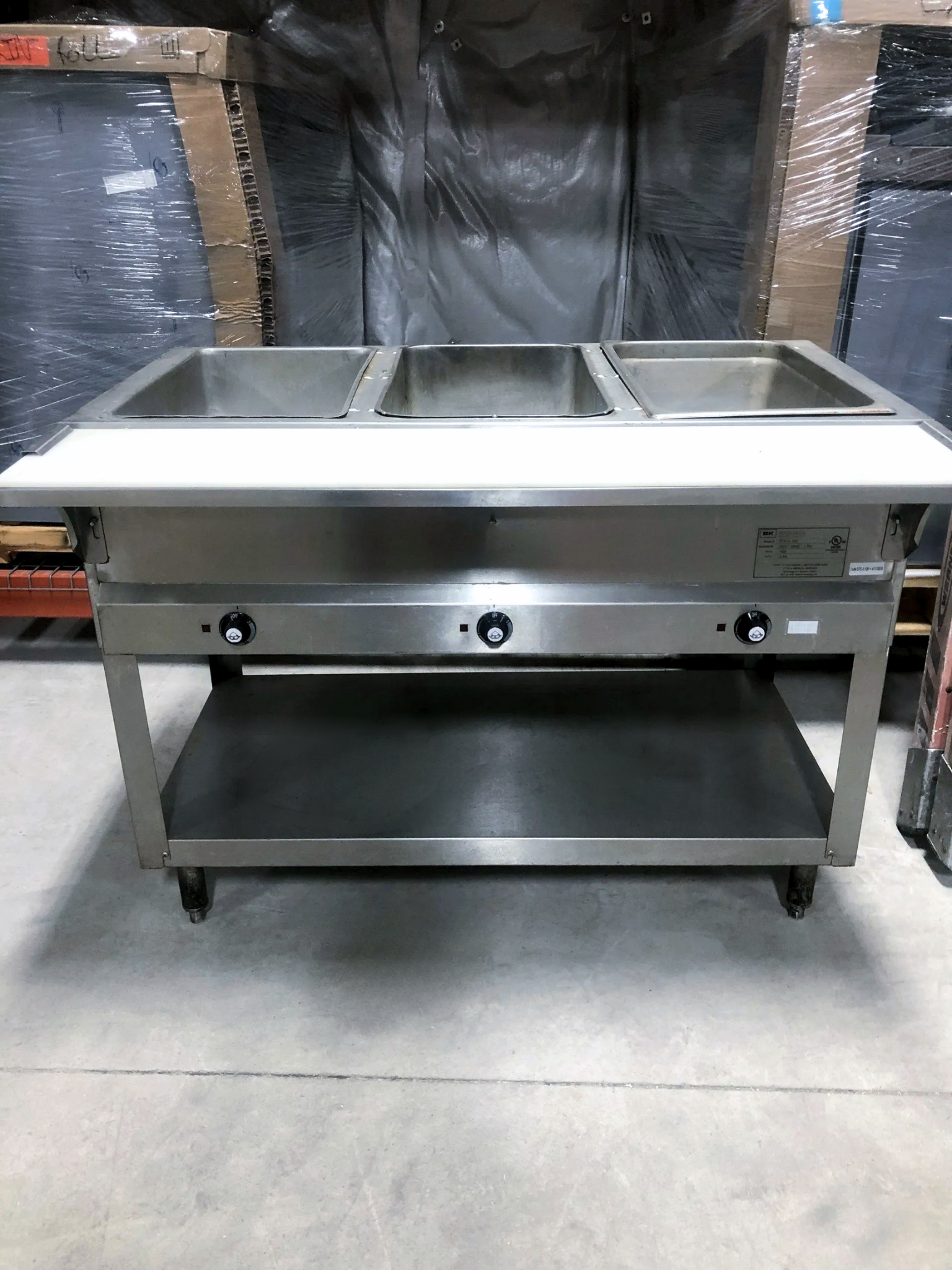 a stainless steel food warmer with a shelf underneath it