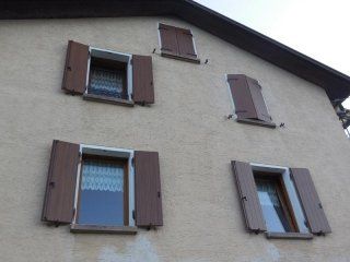 facciata con finestre con battenti in legno