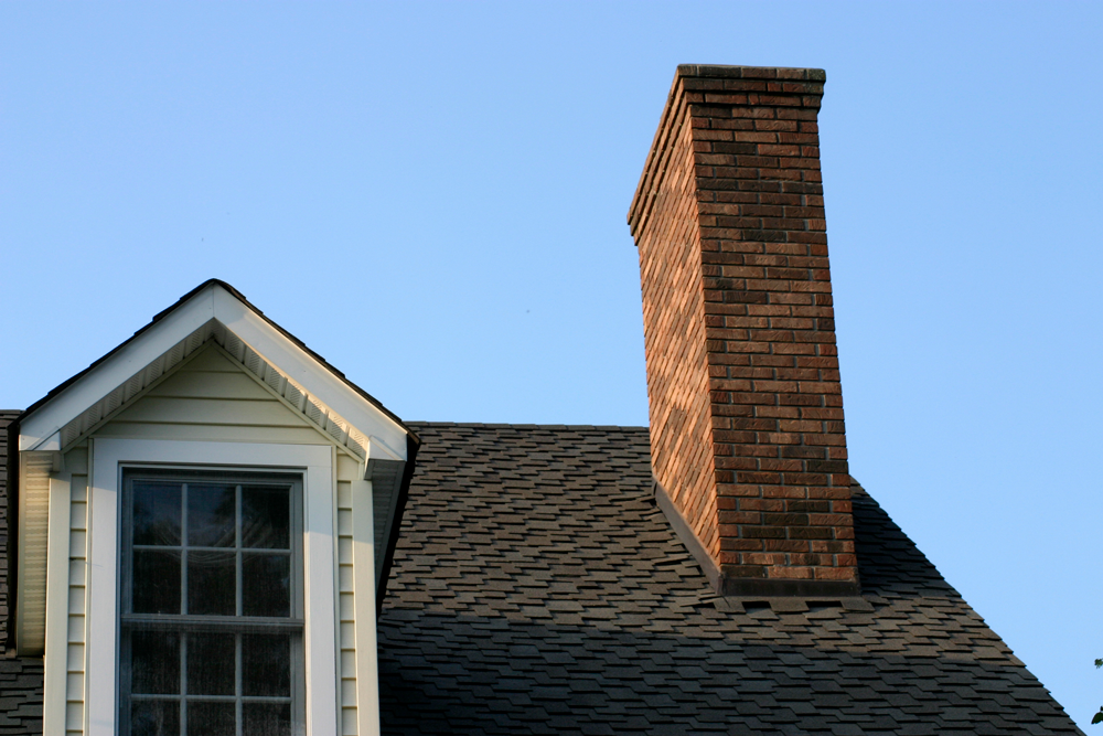 A brick chimney on the roof of a house