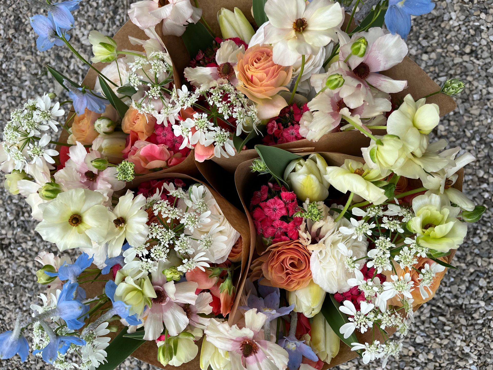 Spring bouquets featuring blue delphinium, butterfly ranunculus, tulips and more