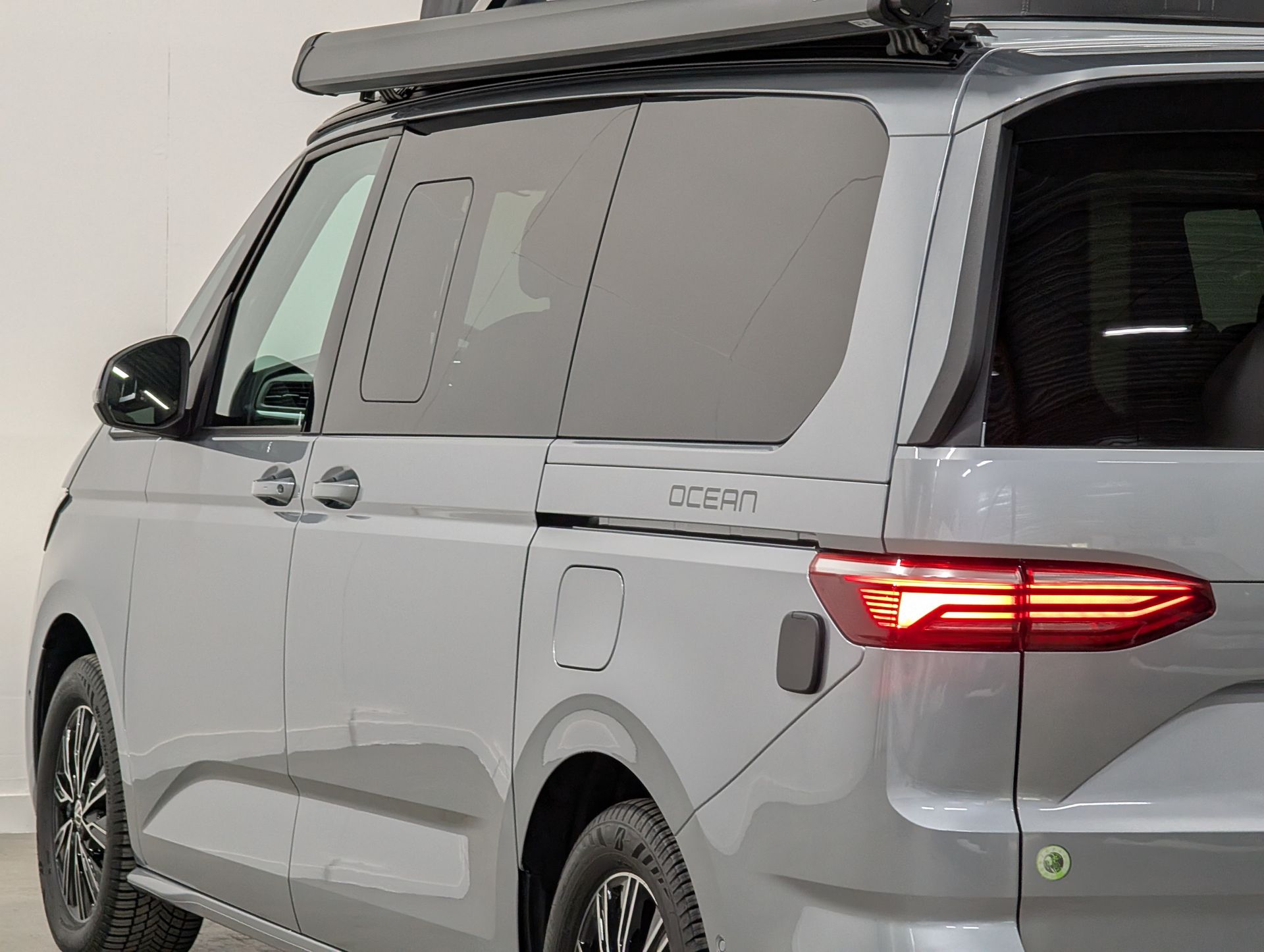 Volkswagen California Ocean eHybrid in de kleur Mono Silver detailfoto van linkeraanzicht met luifel ingeklapt