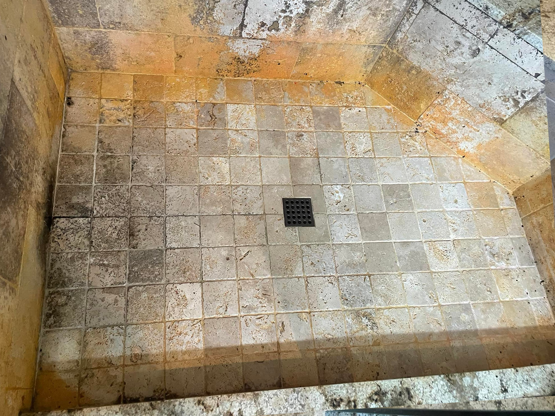 Stone wall with a small, square metal grate, possibly in a building's stairwell.