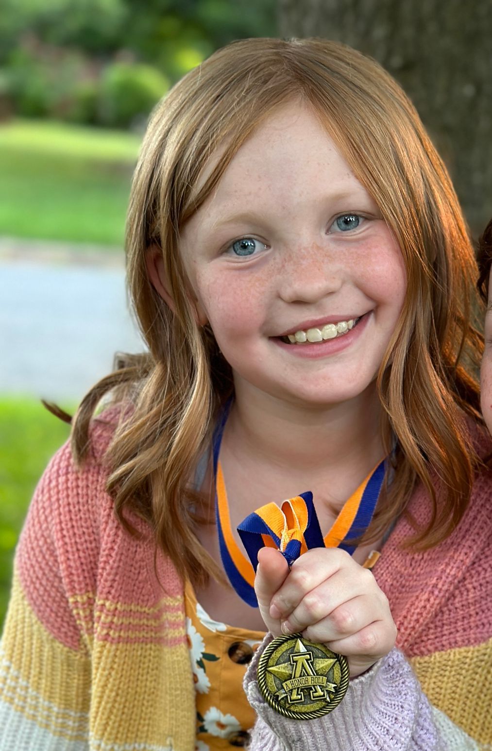 Picture of Willow holding a scholar roll medal for her real stories section
