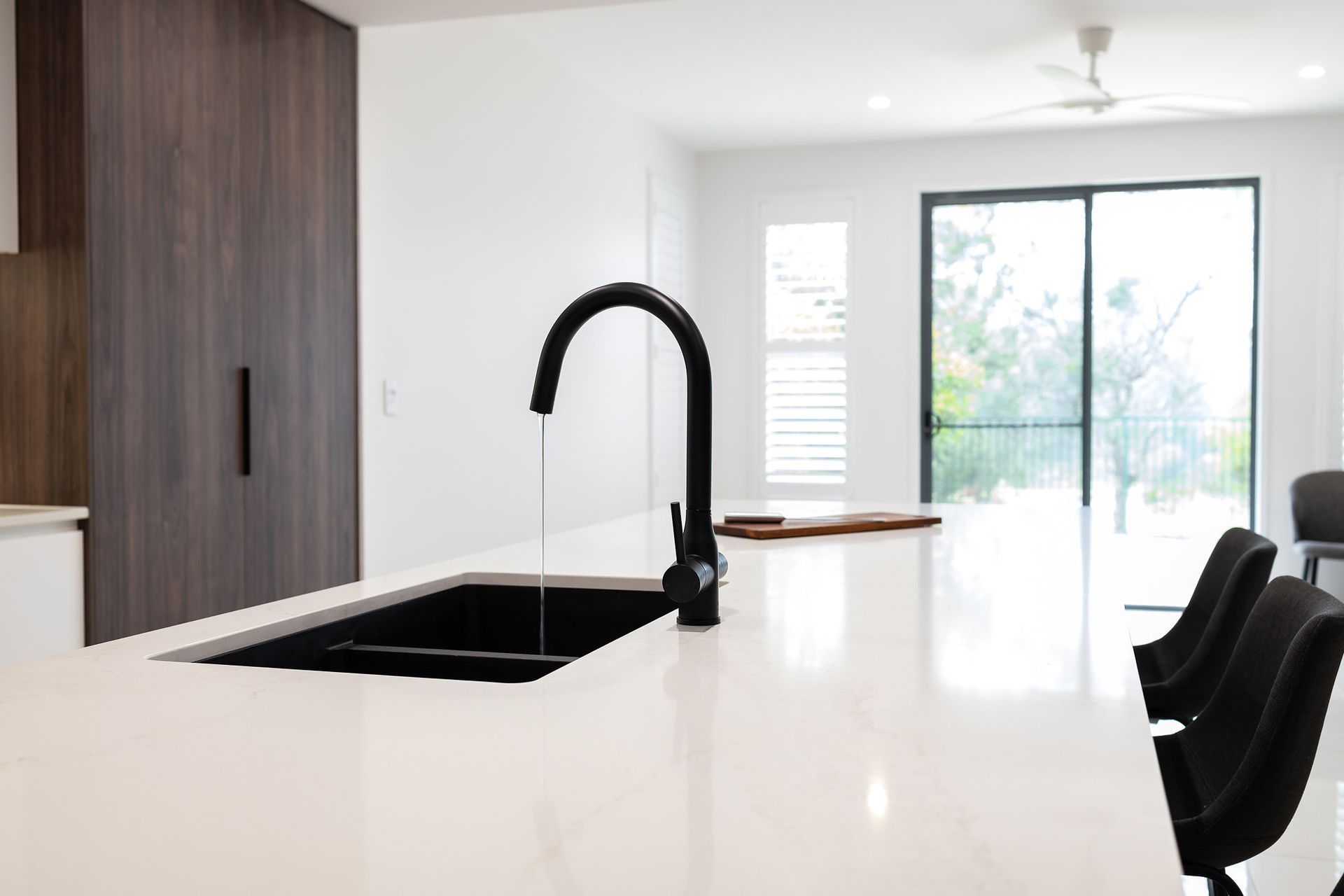 Black Faucet Over a Black Sink in a Modern Kitchen With a White Countertop — Truline Cabinets In Tuchekoi, QLD