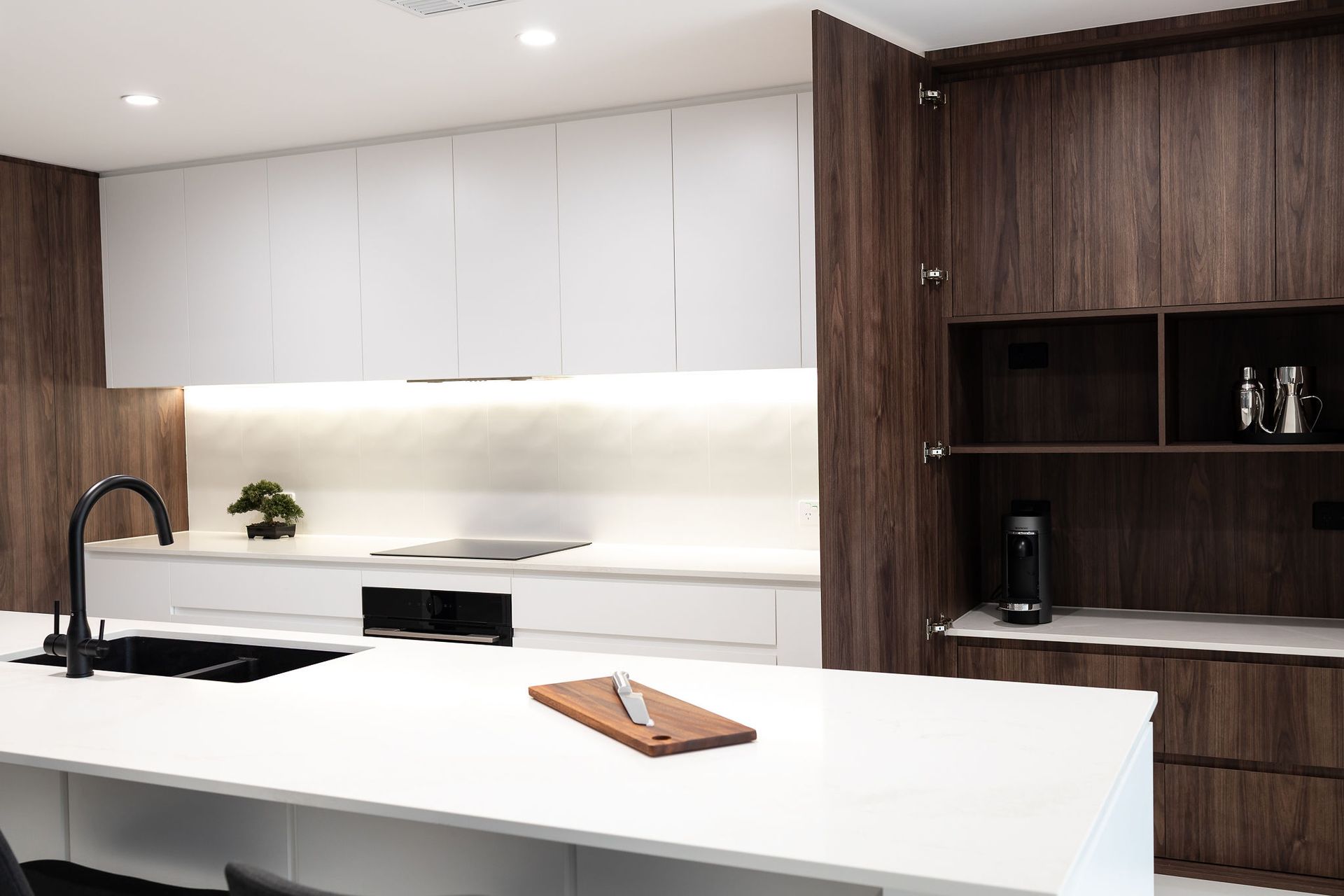 Modern Kitchen With White Countertops and Cabinets, Dark Wood Accents, and a Black Faucet — Truline Cabinets In Tuchekoi, QLD