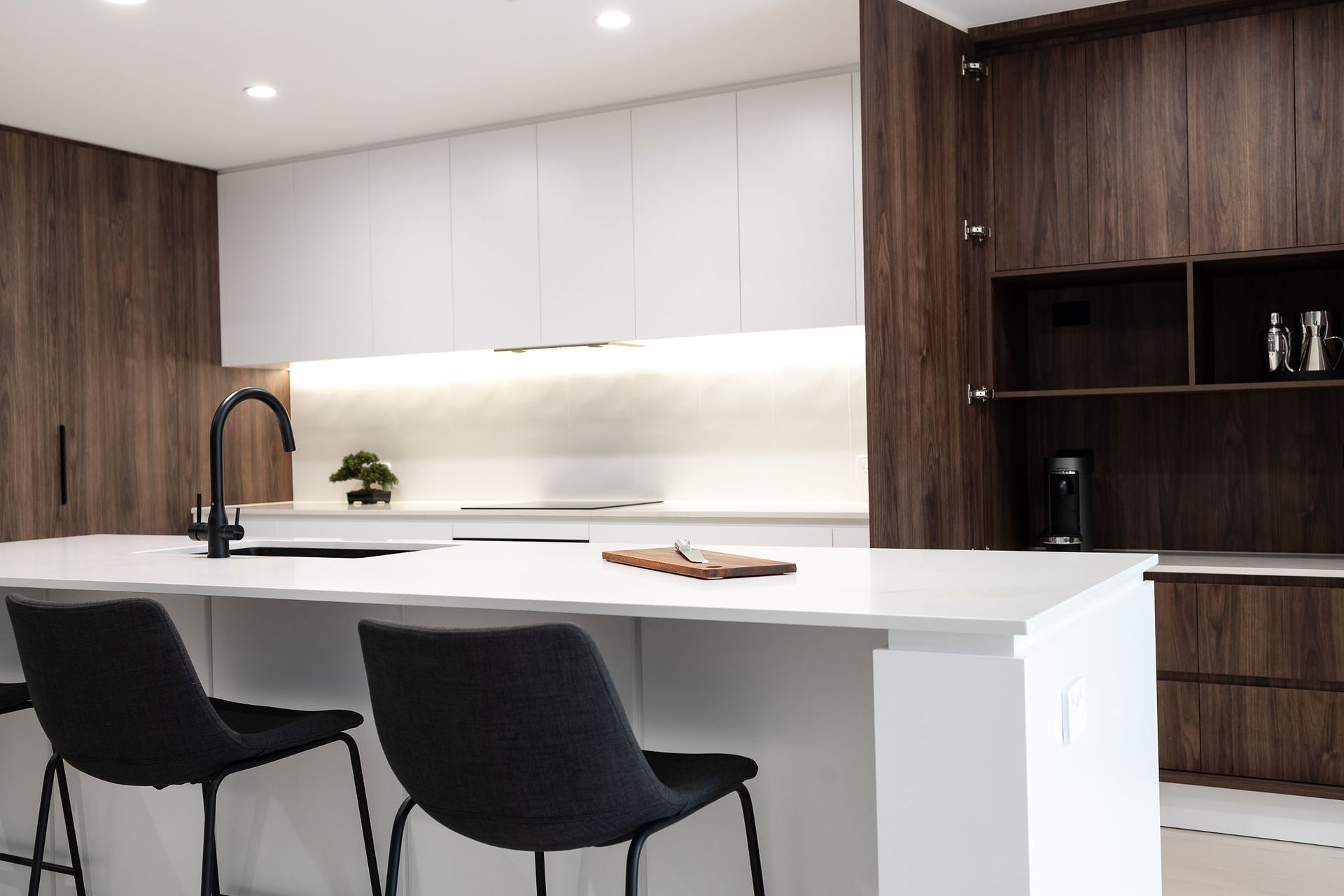 Modern Kitchen With White Island, Dark Wood Cabinets, and Black Bar Stools — Truline Cabinets In Tuchekoi, QLD