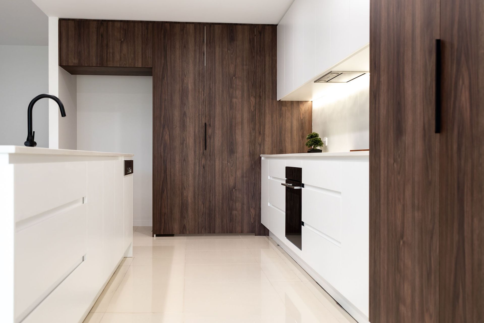Modern Kitchen With White Cabinets, Brown Wood Cabinets, and Black Fixtures — Truline Cabinets In Tuchekoi, QLD