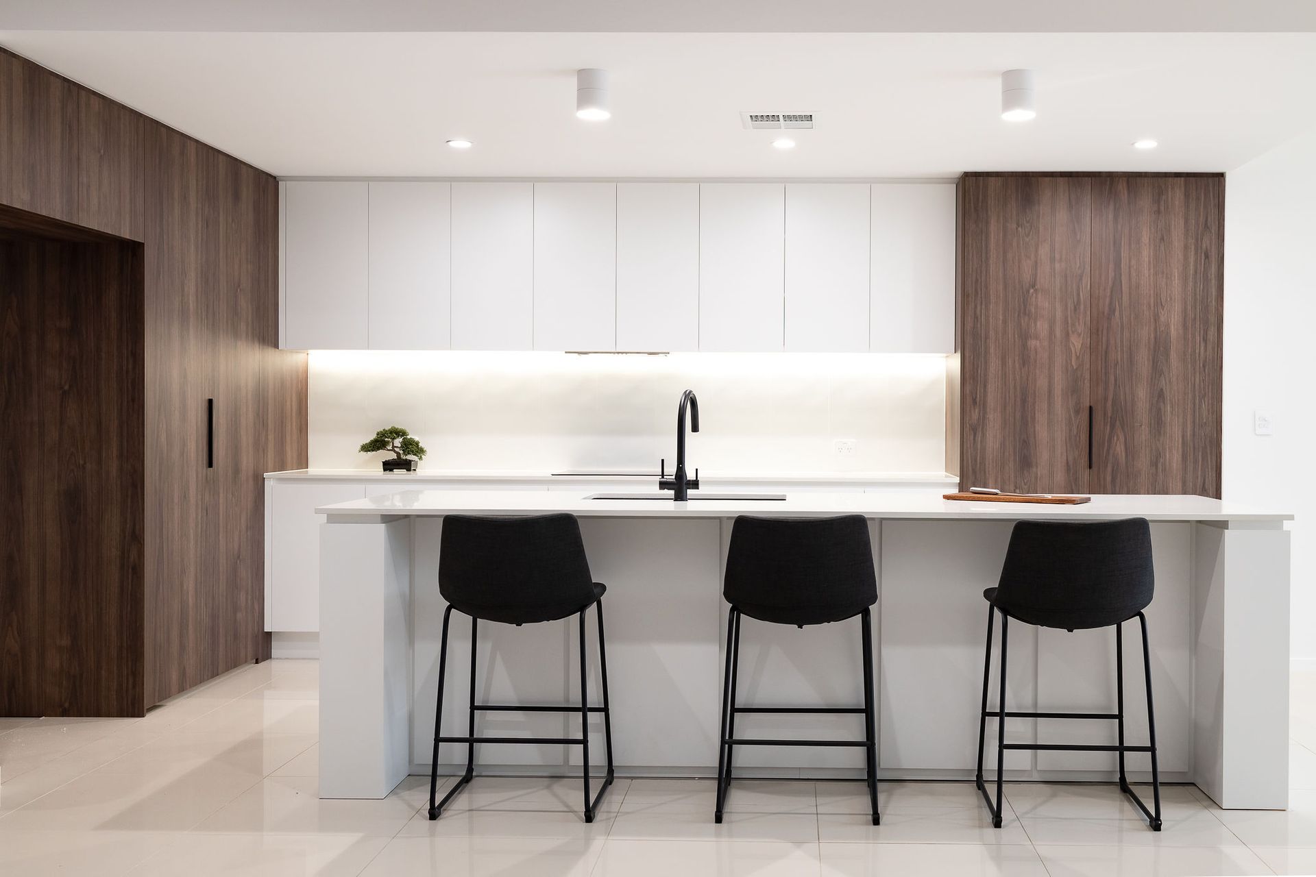 Modern Kitchen With White and Wood Cabinetry, Island With Black Stools — Truline Cabinets In Tuchekoi, QLD