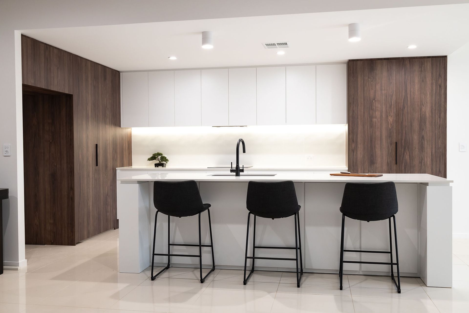 Modern Kitchen With White and Wood Cabinetry, Island With Black Stools — Truline Cabinets In Tuchekoi, QLD