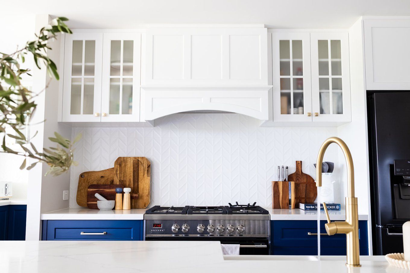 White and Blue Kitchen With a Gold Faucet, Wooden Cutting Boards, and a Stainless Steel Stovetop — Truline Cabinets In Tuchekoi, QLD