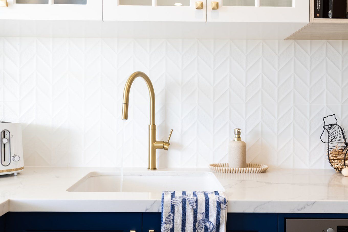 Gold Faucet Over a White Kitchen Sink, Set Against White Patterned Tile Backsplash — Truline Cabinets In Tuchekoi, QLD