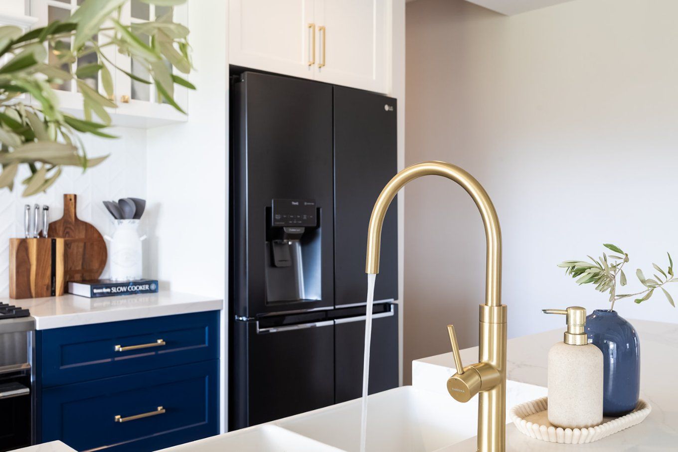 Modern Kitchen Featuring a Matte Black Refrigerator, Gold Faucet, and Navy Blue Cabinets — Truline Cabinets In Tuchekoi, QLD