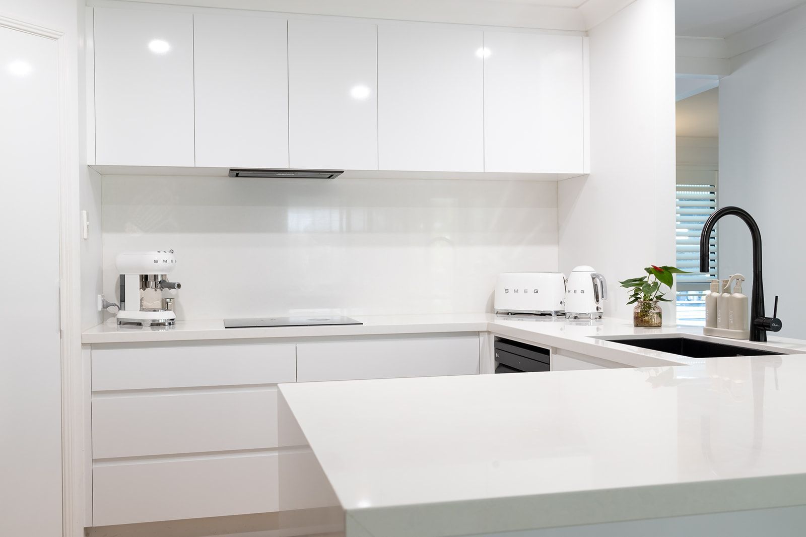 White Modern Kitchen With Glossy Cabinets, Island, and Black Faucet — Truline Cabinets In Tuchekoi, QLD