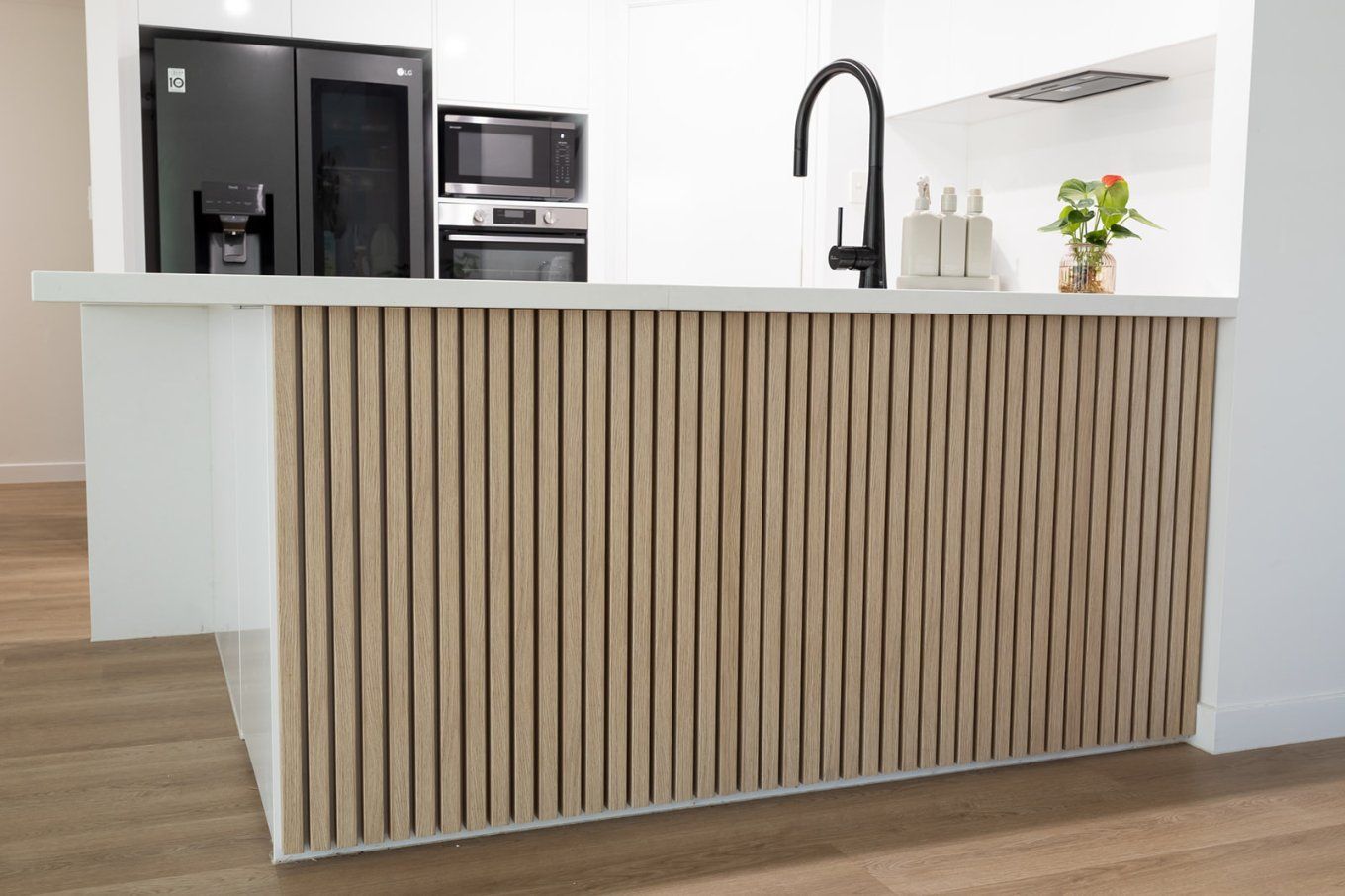 Kitchen Island With Light Wood Vertical Slats, White Countertop and Base — Truline Cabinets In Tuchekoi, QLD