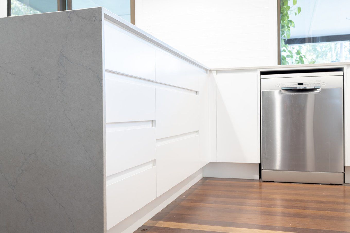 White Kitchen Cabinets and a Stainless Steel Dishwasher — Truline Cabinets In Tuchekoi, QLD