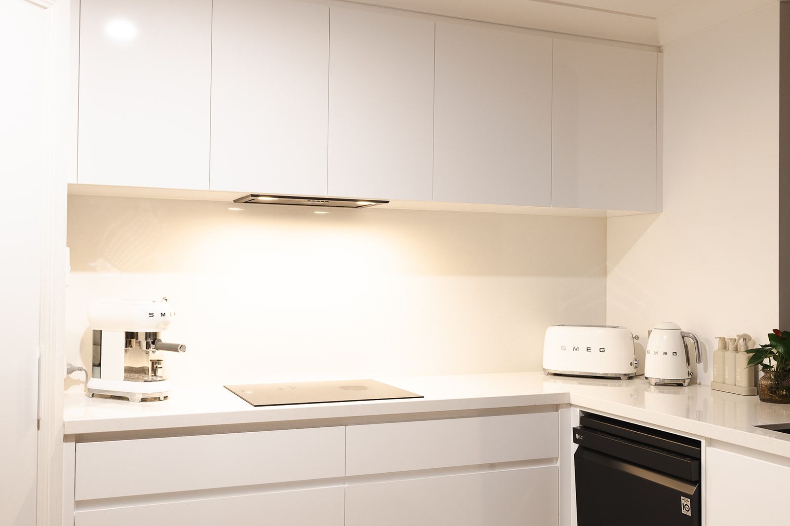 Modern White Kitchen With Overhead Cabinets, Countertop, Stovetop, Appliances, and Built-in Oven — Truline Cabinets In Tuchekoi, QLD