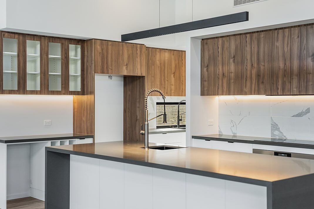 Modern Kitchen With Wood Cabinets, White Island, Grey Countertops, and Glass-front Cabinets — Truline Cabinets In Tuchekoi, QLD