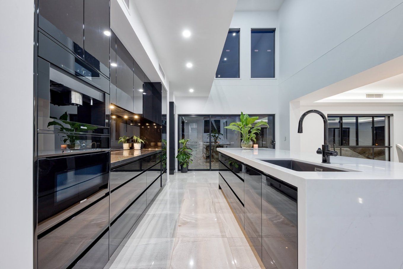 Modern Kitchen With Glossy Black Cabinetry, White Countertops, and Black Faucet — Truline Cabinets In Tuchekoi, QLD