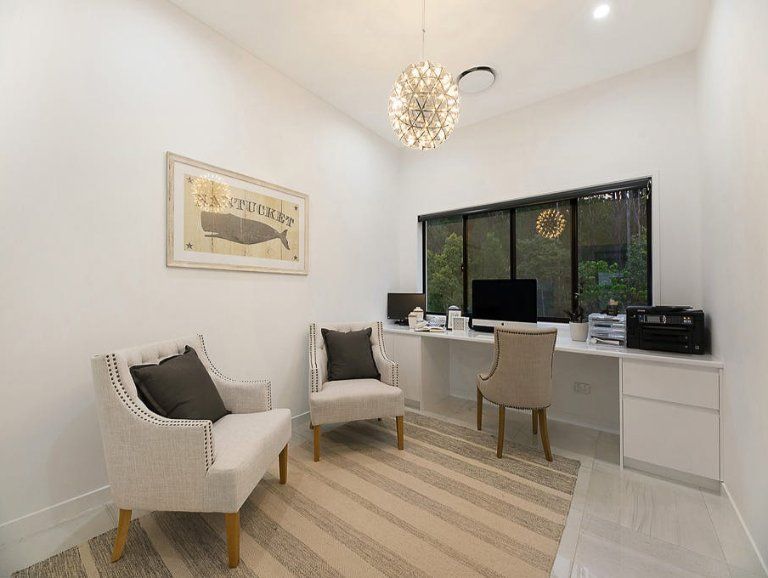 A Bright Home Office With Two Armchairs, a Desk, and a Large Window Overlooking Greenery — Truline Cabinets In Tuchekoi, QLD
