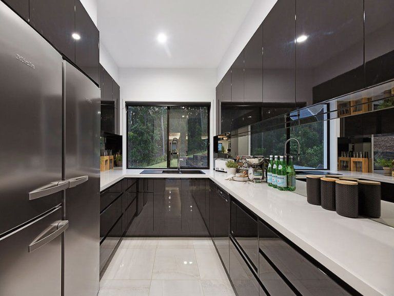 Modern Galley Kitchen With Dark Glossy Cabinets, Stainless Steel Refrigerator, and White Countertops — Truline Cabinets In Tuchekoi, QLD