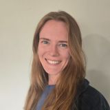 A close up of a woman 's face smiling in a car.