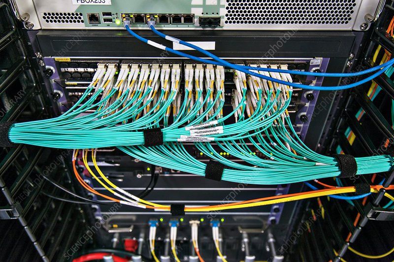 A bunch of wires are connected to a server in a server room