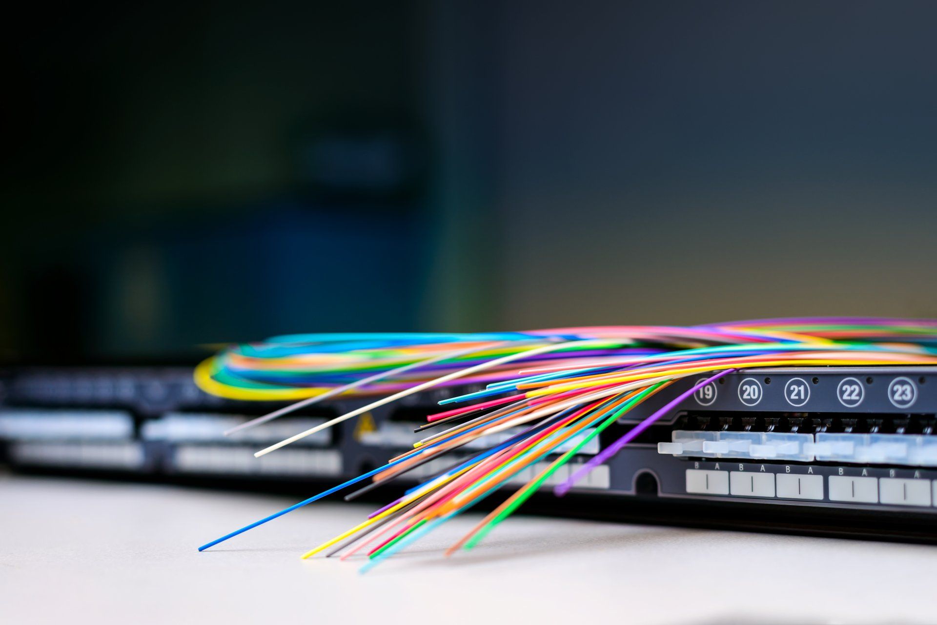 Colorful fiber optic strands on top of a router depict broadband fiber connectivity