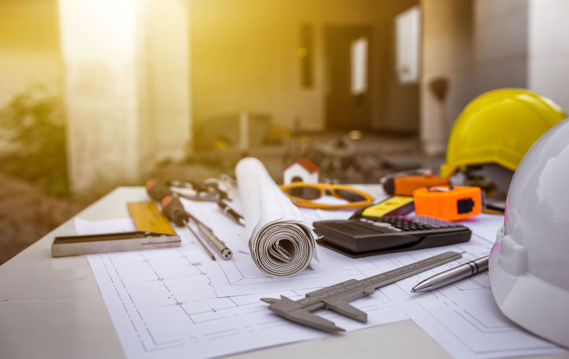 A hard hat is sitting on top of a table with construction tools.