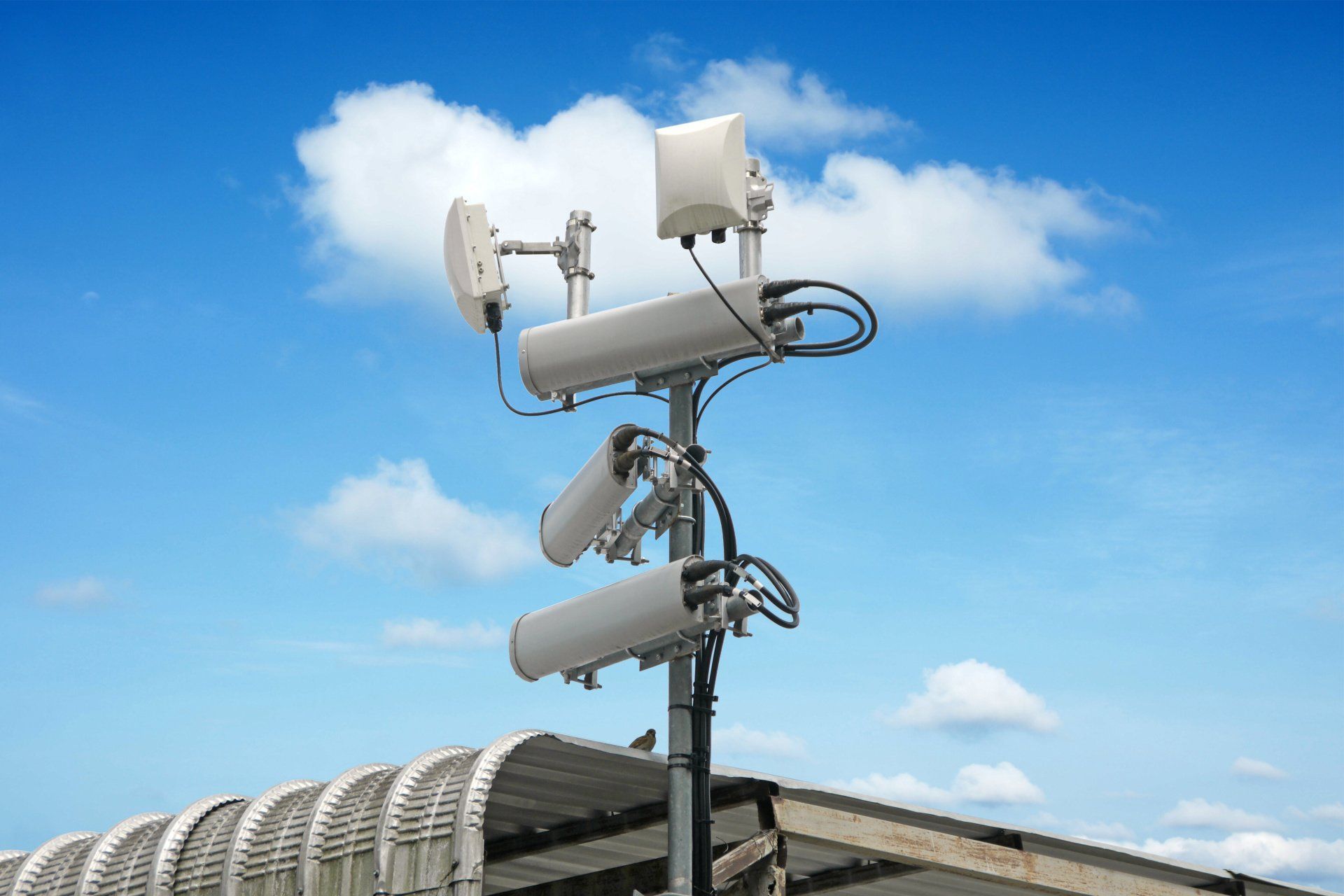 Outdoor distributed antenna system (DAS) against blue sky boosts wireless signal in the area