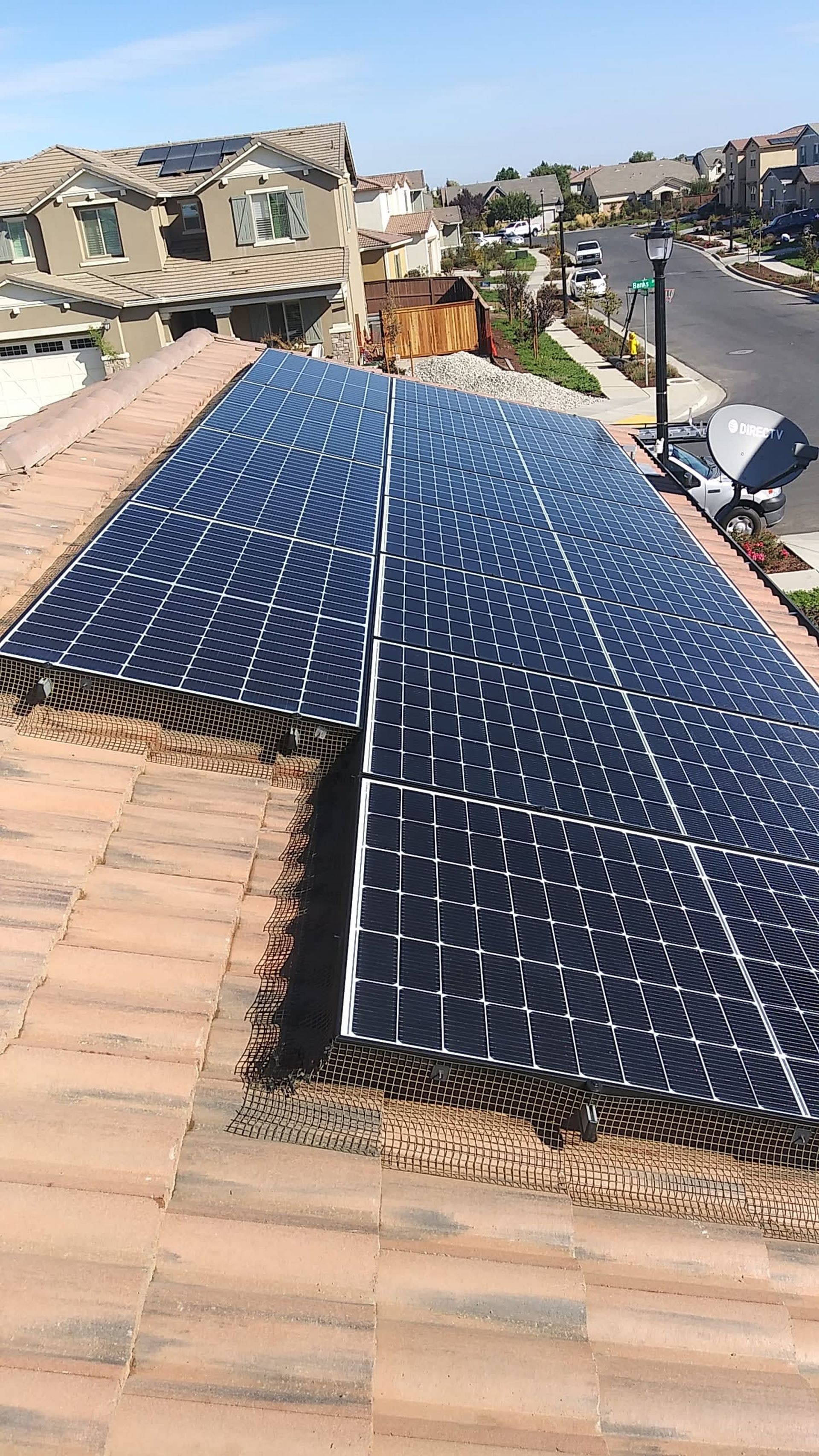 Solar panels installed on a residential tile roof on a sunny day.