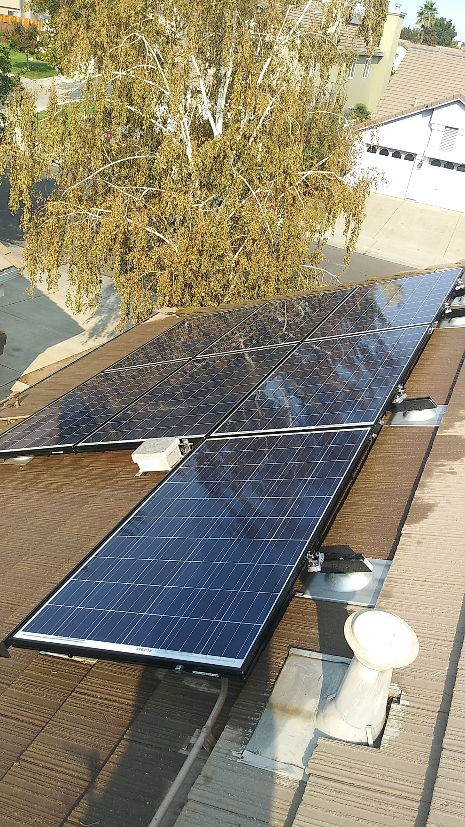 Solar panels on a residential rooftop, reflecting sunlight. 