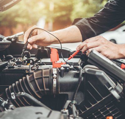 Complete Auto Repair — Mechanic Checking Car Battery in