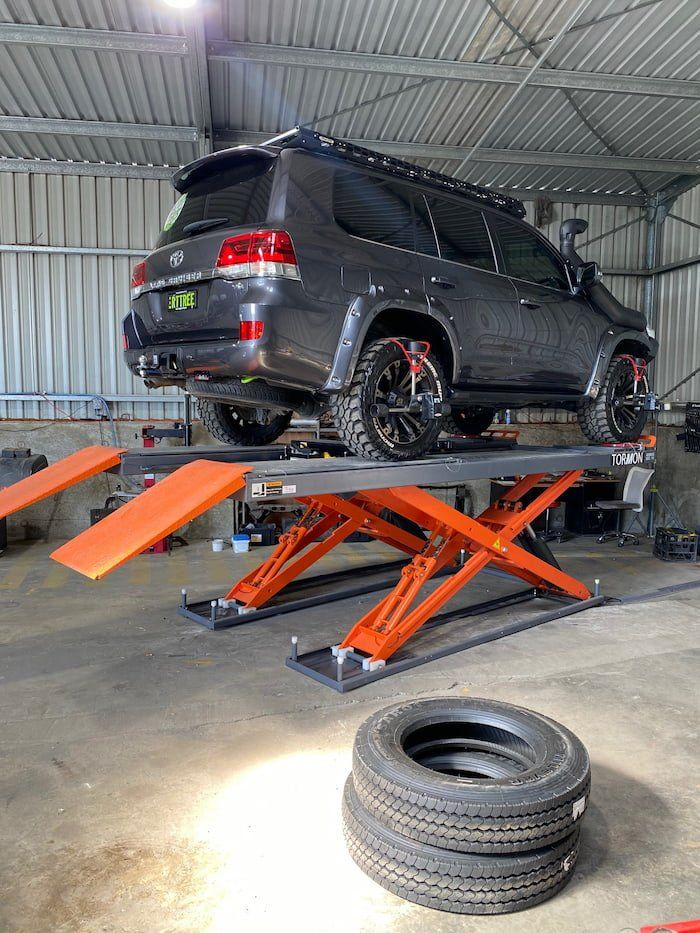 Car on a Scissor Lift — Wheel and Tyre Services in Inverell, NSW