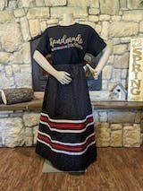 A mannequin wearing a dress and a t-shirt is standing in front of a fireplace.
