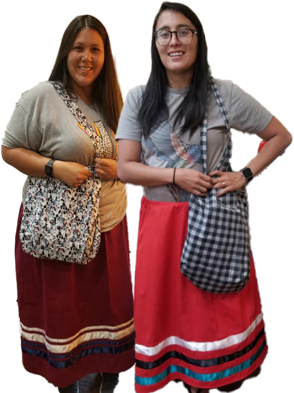 Two women standing next to each other with their hands on their hips holding a bag.