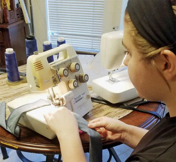 A woman is using a brother sewing machine