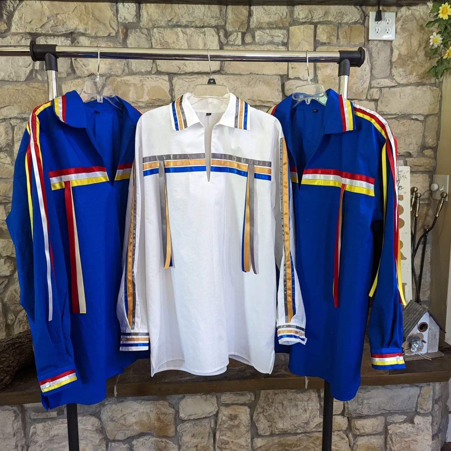 Three blue and white shirts are hanging on a rack, wedding collection