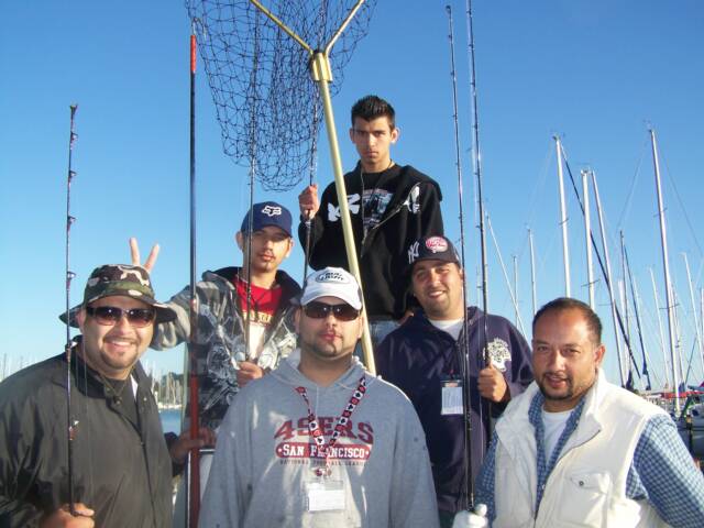 A group of men posing for a picture with one wearing a san francisco 49ers shirt
