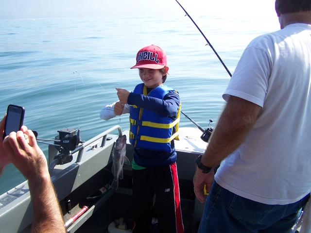 A young boy wearing a red hat that says aqua