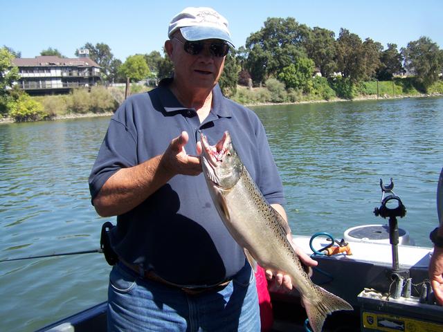A man on a boat holding a large fish