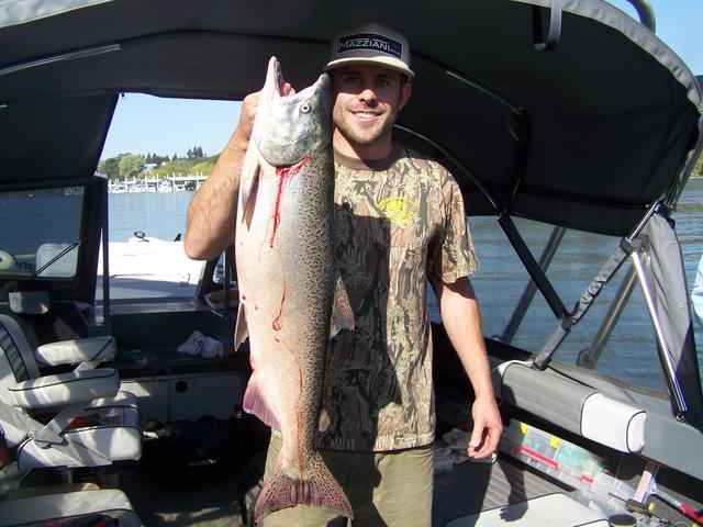 A man holding a large fish in front of a boat