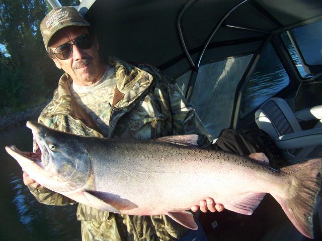 A man is holding a large fish in his hands