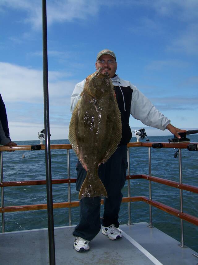 A man is holding a large fish on a boat