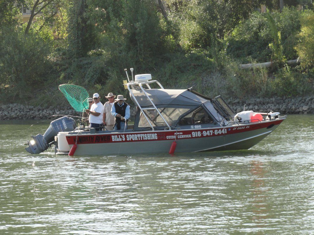 A group of people are standing on a boat in the water.
