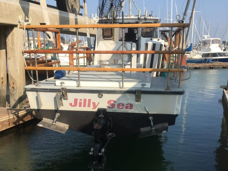 A boat called jilly sea is docked at a marina